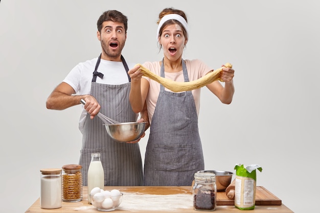 Ehemann und ehefrau posieren in der küche und bereiten ein leckeres abendessen vor