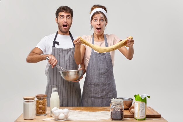 Ehemann und Ehefrau posieren in der Küche und bereiten ein leckeres Abendessen vor