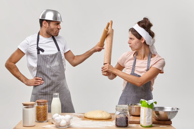 Ehemann und Ehefrau posieren in der Küche und bereiten ein leckeres Abendessen vor