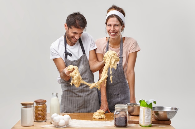 Ehemann und Ehefrau posieren in der Küche und bereiten ein leckeres Abendessen vor