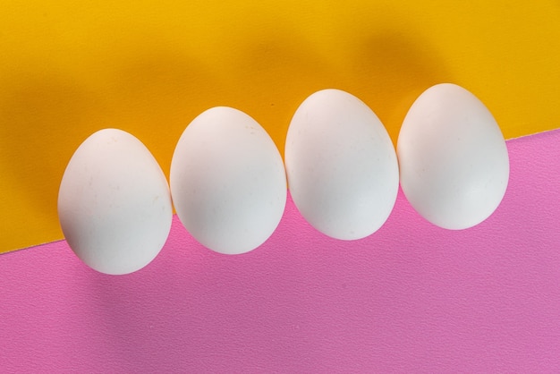 Eier auf dem gelben und rosa Tisch