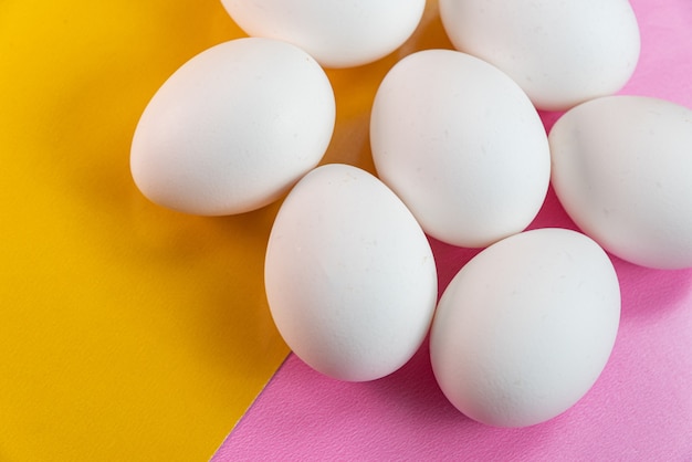 Kostenloses Foto eier auf dem gelben und rosa tisch