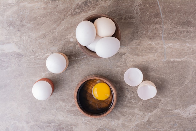 Kostenloses Foto eier, eierschalen und eigelb in einer holztasse