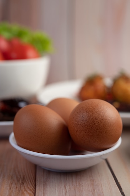 Eier in einer Tasse auf einem Holzboden platziert.