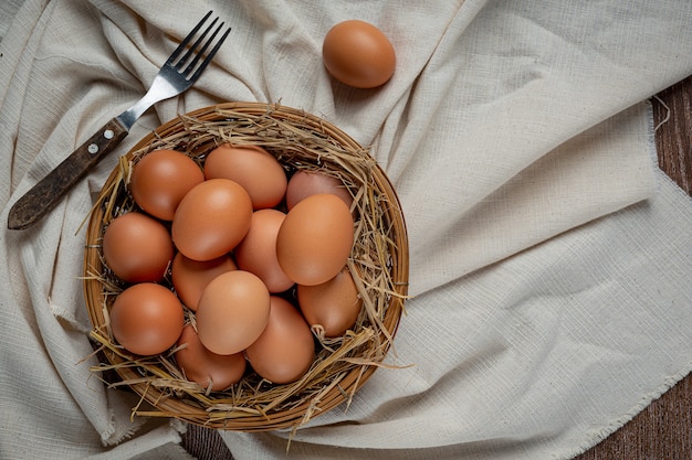 Eier in Tassen auf Sackleinen mit trockenem Gras.