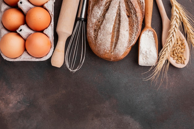 Eierkarton mit Schneebesen und gebackenem Brot