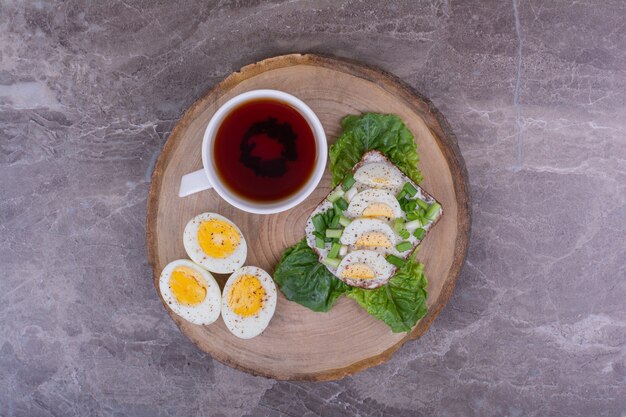 Eiersandwich mit Kräutern und einer Tasse Tee