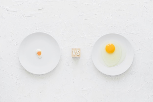 Eiersüßigkeiten gegen Eigelb auf weißer Platte über strukturiertem Hintergrund