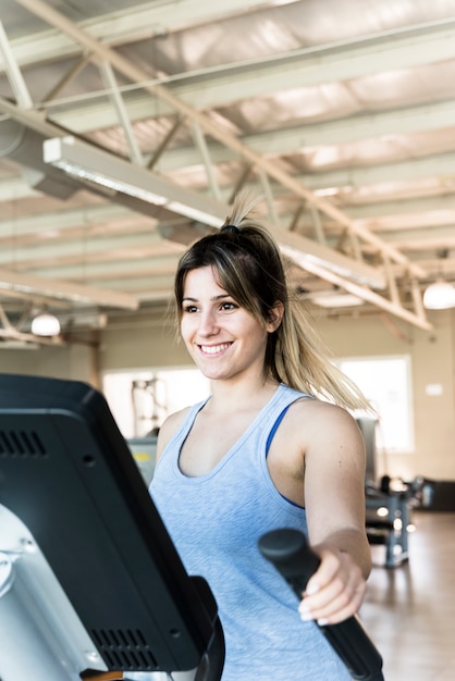 Eignungsmädchen, das elliptischen Trainer verwendet