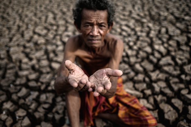 Ein älterer Mann saß und bat um Regen in der Trockenzeit, die globale Erwärmung