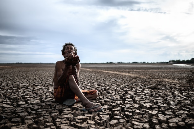 Ein älterer Mann saß und bat um Regen in der Trockenzeit, die globale Erwärmung