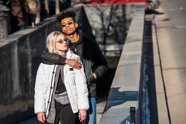 Ein afrikanischer junger Mann, der seine Freundin von hinten umfasst