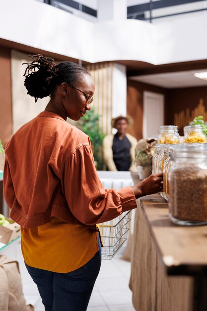 Ein afroamerikanischer Kunde kauft in einem Lebensmittelgeschäft frische, lokal angebaute Produkte ein. Sie bestätigen, dass es sich um Bioprodukte handelt