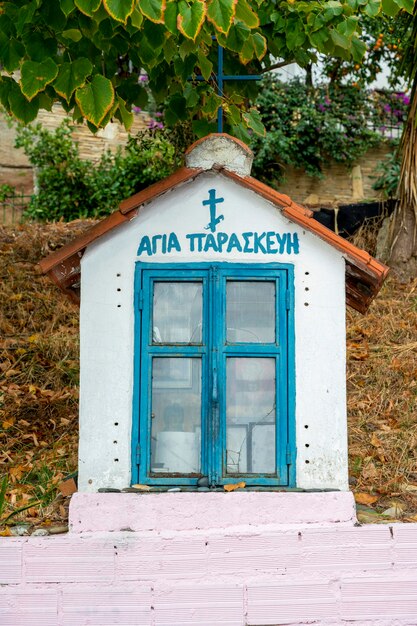 Ein alter Schrein auf der Straße aus Stein mit Ikonen innen in Skala Fourkas, Griechenland