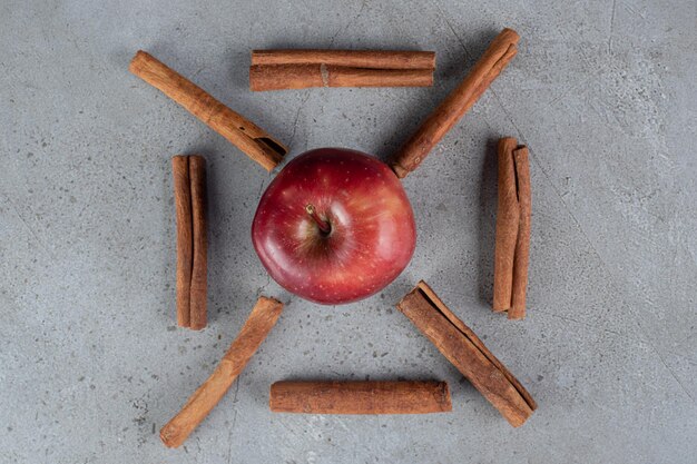 Kostenloses Foto ein apfel und zimt schneidet dekorativ auf marmoroberfläche angeordnet