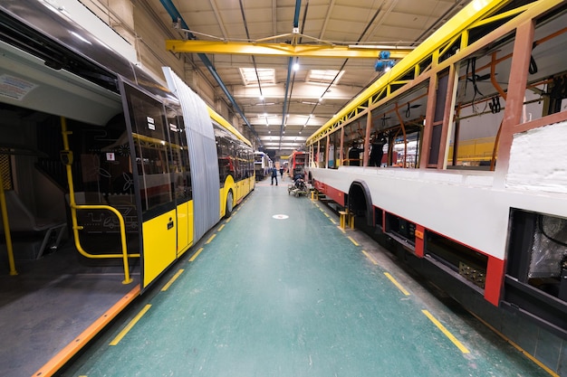 Ein Arbeitstag der modernen automatischen Busherstellung mit unfertigen Autoarbeitern in der schützenden einheitlichen Automobilindustrie