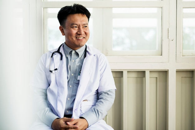 Ein asiatischer Doktor, der an einem Krankenhaus arbeitet