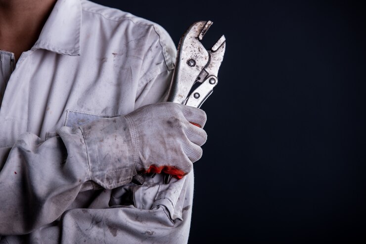 Kostenlose Foto ein automechaniker trägt eine weiße uniform und hält einen schraubenschlüssel