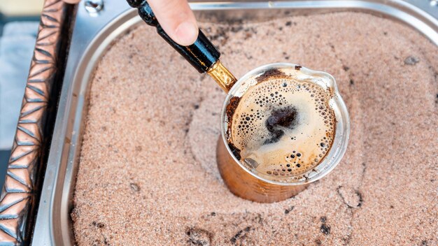 Ein Barista, der Kaffee auf dem Sand in Istanbul die Türkei kocht