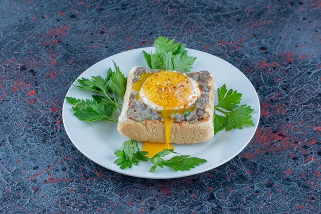 Ein blauer Teller mit köstlichem Toast mit Fleisch und Gemüse.