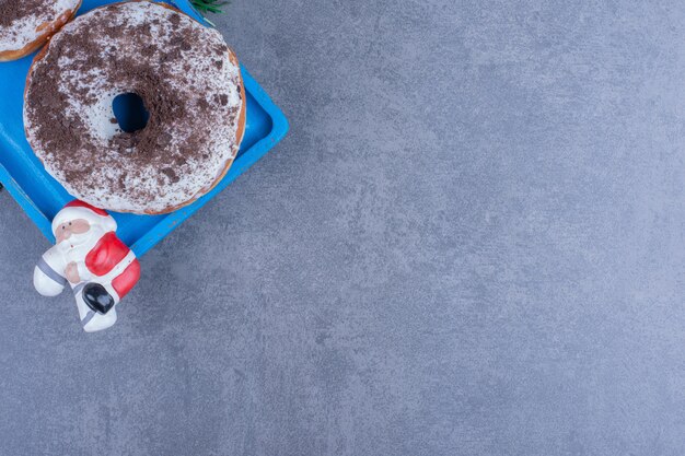 Ein blaues Brett der süßen Schokoladenplätzchen mit Weihnachtsspielzeug