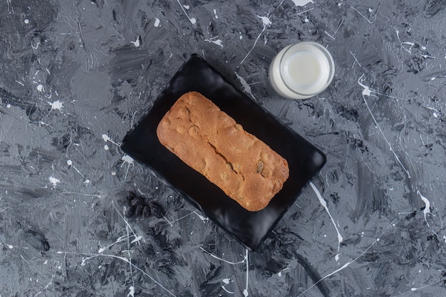 Ein Brett mit frisch gebackenem Rosinenbrot auf einer Marmoroberfläche.