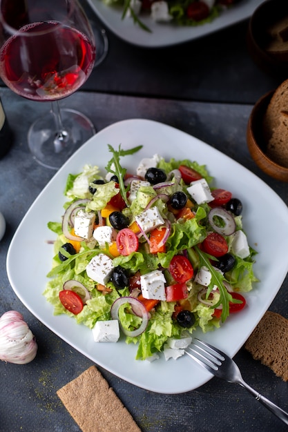 Ein Draufsicht Griechenland Salat geschnittene Oliven Rotwein in Weißplatte