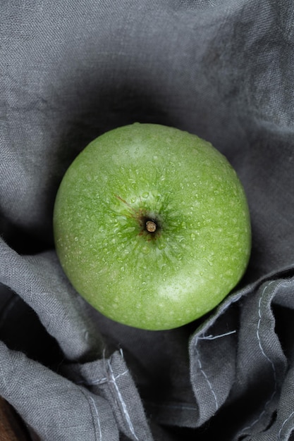 Ein einzelner grüner Apfel getrennt auf Grau.