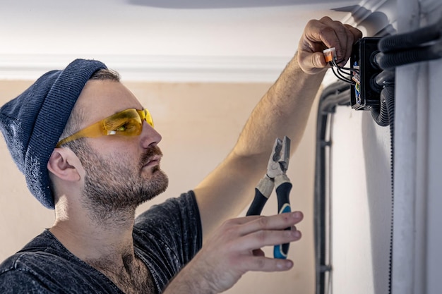 Kostenloses Foto ein elektriker montiert steckdosen an der weißen wand im haus