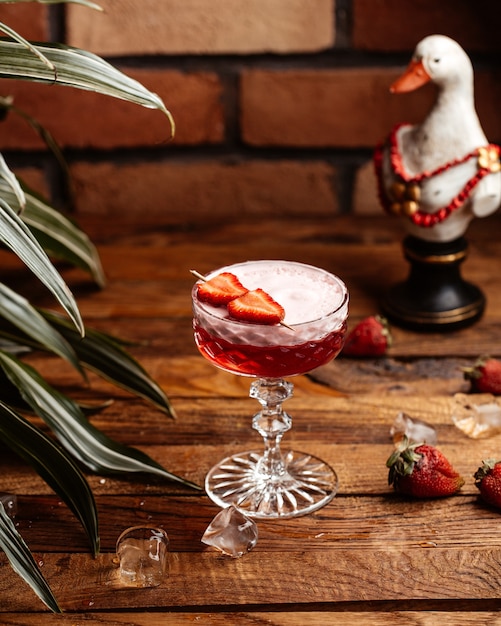 Ein Erdbeercocktail mit Vorderansicht und frischen roten Erdbeeren auf dem Tisch trinkt Cocktailsaftfrucht