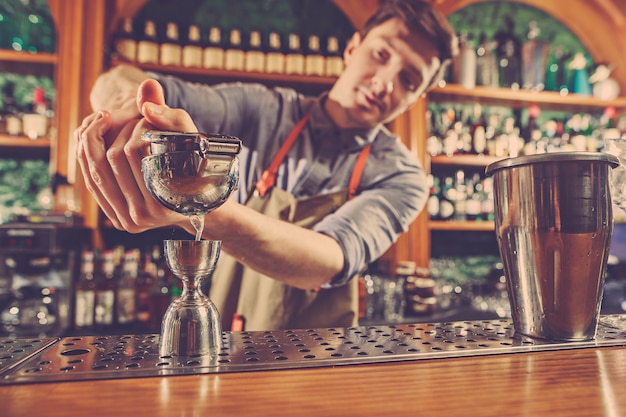 Ein erfahrener Barmann macht einen Cocktail im Nachtclub.