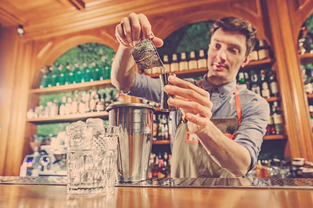 Ein erfahrener Barmann macht einen Cocktail im Nachtclub.