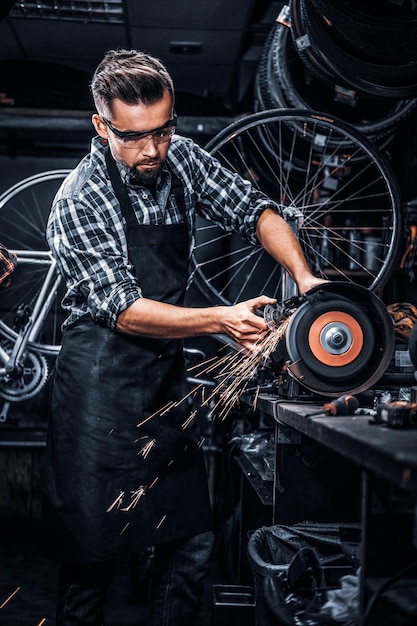 Kostenloses Foto ein erfahrener reparaturmeister arbeitet mit werkzeugmaschinen in einer geschäftigen bucycle-werkstatt.