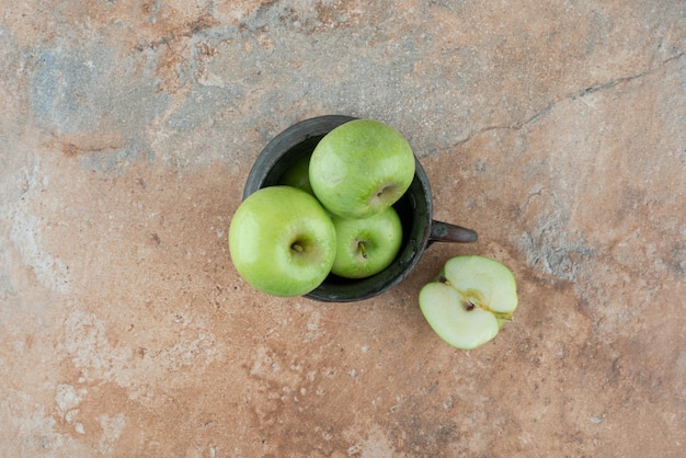 Ein frischer Apfel mit einer alten Tasse auf Marmor