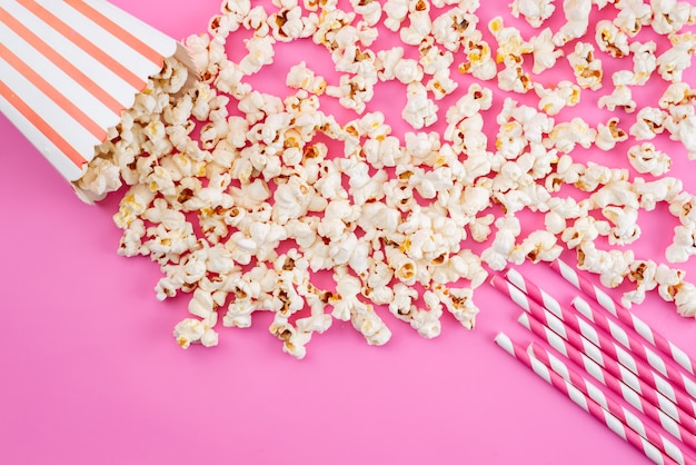 Ein frisches Popcorn von oben zeigt alles auf rosa Filmmaissnack