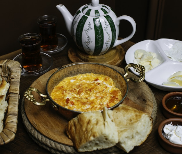 Ein Frühstückstisch aus der Nähe mit gekochten Eiern und heißem Tee auf dem braunen Boden
