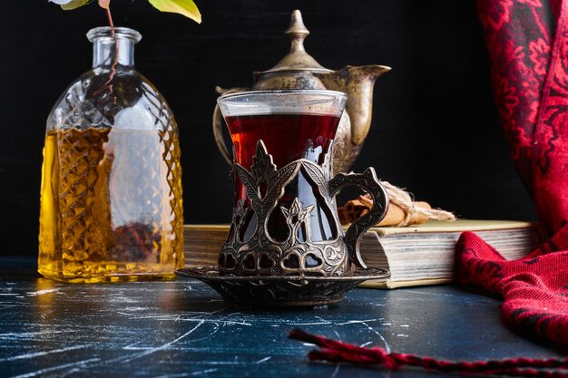 Ein Glas Earl Grey Tea auf blauer Oberfläche.