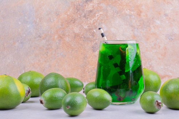 Ein Glas grünes Getränk mit Feijoa und Mandarinen