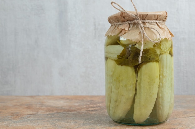 Ein Glas hausgemachte eingelegte Gurken auf Marmortisch