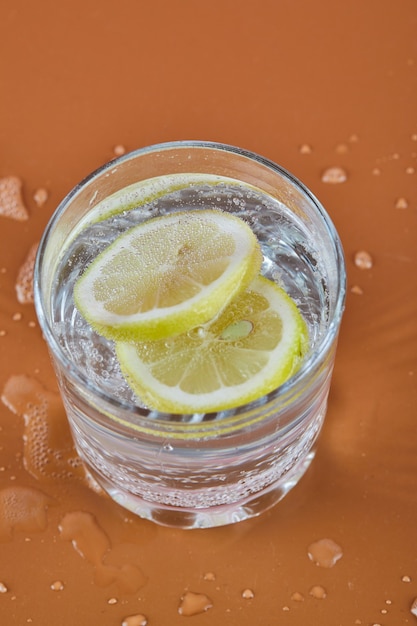 Kostenloses Foto ein glas kalte erfrischende limonade auf orange oberfläche