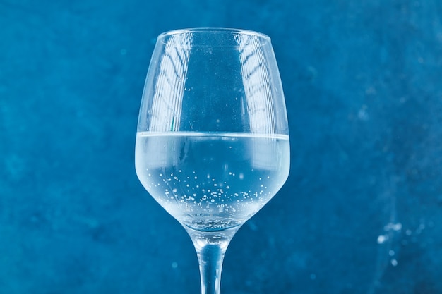 Ein Glas Mineralwasser auf blauer Oberfläche
