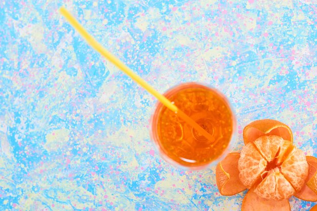 Ein Glas Orangensaft mit Mandarinen in der unteren Ecke. Hochwertiges Foto