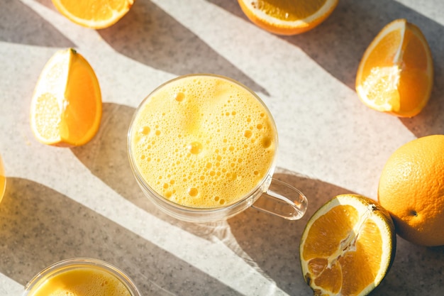 Ein Glas Orangensaft und Obsthälften von Orangen auf dem Küchentisch