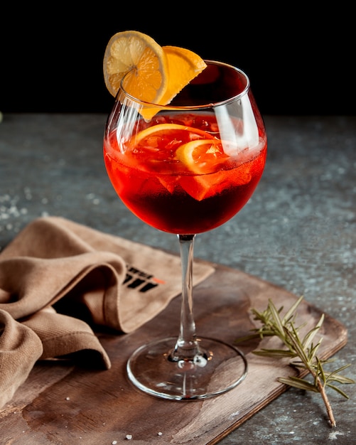 Ein Glas roter Cocktail, garniert mit Orangenscheiben