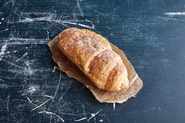 Ein großes Croissant auf einem Stück Papier.