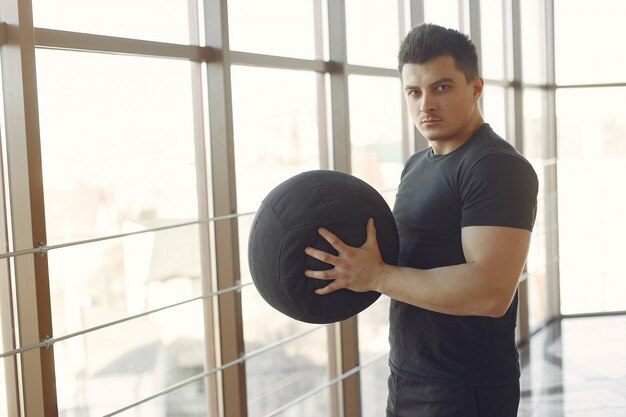 Ein gutaussehender Mann ist in einem Fitnessstudio beschäftigt