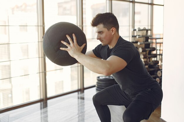 Ein gutaussehender Mann ist in einem Fitnessstudio beschäftigt