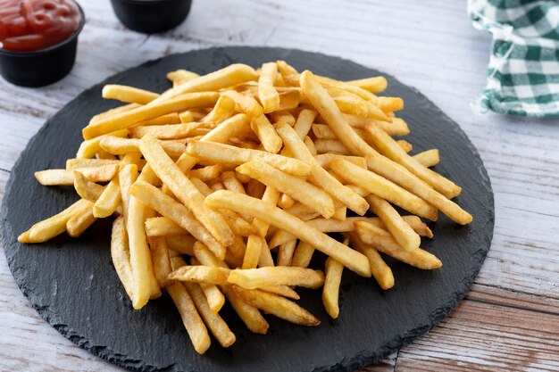 Kostenloses Foto ein haufen pommes auf einem teller mit einer flasche wein.