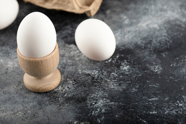 Ein hölzerner Eierbecher mit gekochtem Hühnerei.