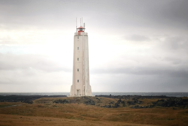 Ein hoher Leuchtturm an der Küste des Meeres